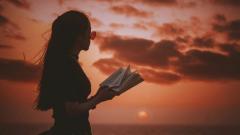 Photo of woman with book at sunset