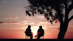 Photo of Two People Talking at Sunset