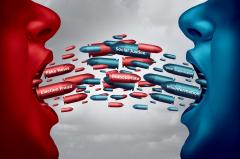A red face and blue face with mouths in a shout facing each other with red and blue bullets coming from their side, words 'Fake News', 'Indoctrinate' and 'Election Fraud' on red bullets, words 'Social Justice', 'Misinformation' and 'Suppression' on blue.