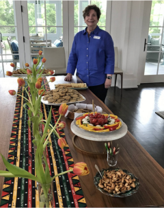 Photo of a woman standing by a table of food