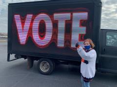 Mary Lou Ezell standing in front of "Vote" sign