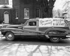 Historical Photo of a vintage car with voting signs