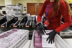 Department of Elections employee Hong Pharmacy Ngo places scanned mail-in and drop-off ballots into bins at City Hall in San Francisco on March 5, 2024. Photo by Juliana Yamada for CalMatters