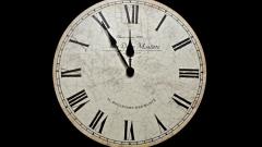 Analog Clock Displaying Five Minutes to Midnight
