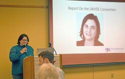 State President Tiffany Lydon at the podium, "Report on the LWVDE Convention" slide in view
