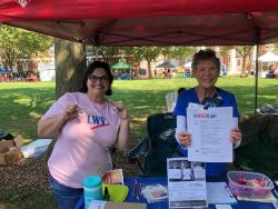 two LWVNCC volunteers shown at an outdoor voter services table