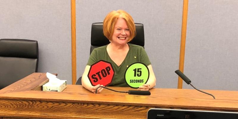 LWV ABC member holding "Stop" and "15 minute" warning signs
