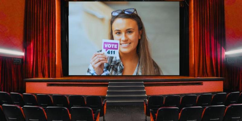 Girl with vote sticker on a movie screen