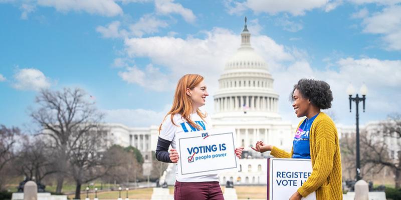 two women promoting voting in front of DC capitol