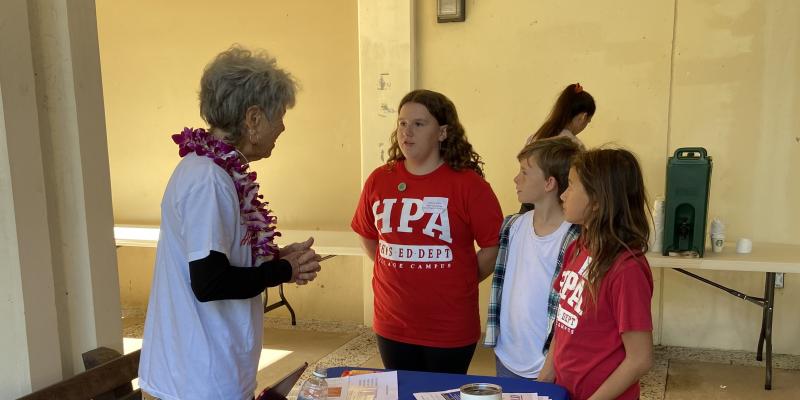 LWV Hawai'i County volunteer Nina Buchanan talks with youth at Hawai'i History Day in Hilo.
