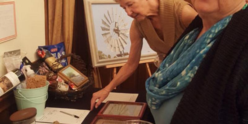 Dorothy Knight and Jan Rudnicki check bid sheets during silent auction Two LWV Hays County members check bid sheets during silent auction