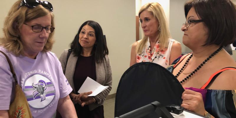 Hays County elections administrator demonstrate Hart hybrid voting machine. photo of county elections staff explaining one model of new hybrid voting machines