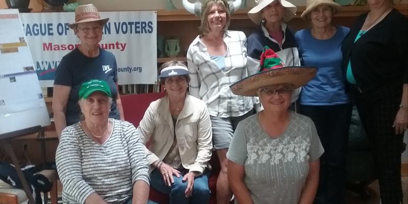 Mason County Board Members at a board retreat don a variety of hats to signifying the many hats they wear, the roles they have taken on, as League board members.