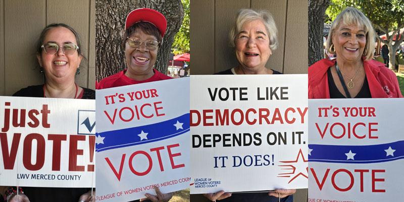 Four women holding vote signs