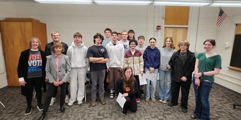 A group of high school students pose with two women from the League of Women Voters.