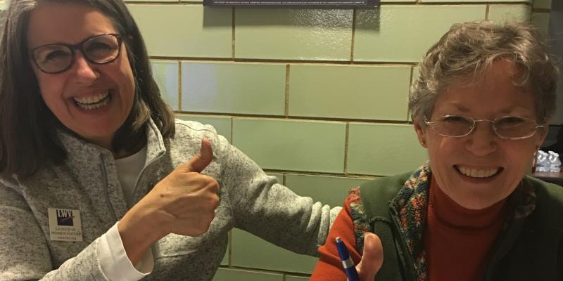 Cami and Carole, registering young voters at an area high school Cami and Carole, smiles and thumbs up in front of "I Will Vote" sign