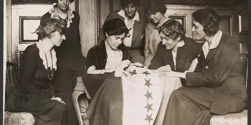 women sewing a star on a banner for nps