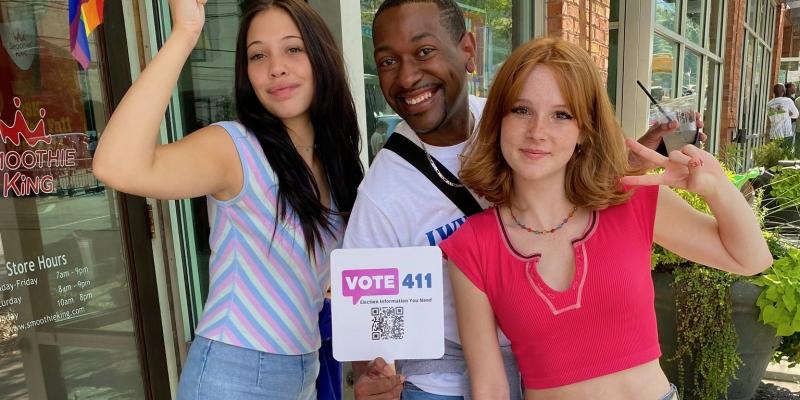 Three w VOTE411 sign, Atlanta pride festival 