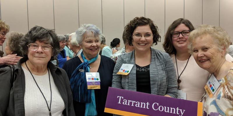 Five LWV Tarrant County (TX) members pose for photo at LWVTX Convention 2018, with Tarrant County sign
