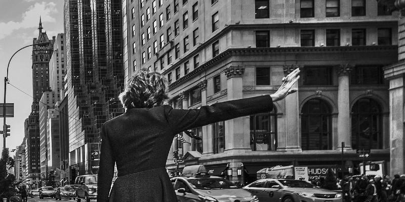 Woman hailing cab, black and white photo