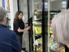 Women stands in front of freezers. 