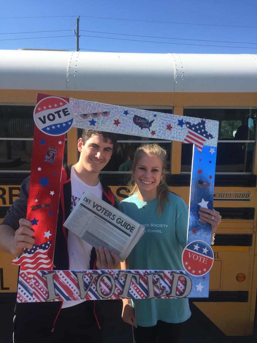 High School Voter Registration Cy-Fair with two students and a voters guide