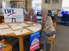 NatVoterRegDay-shows 2 woman LWV tabling inside public library